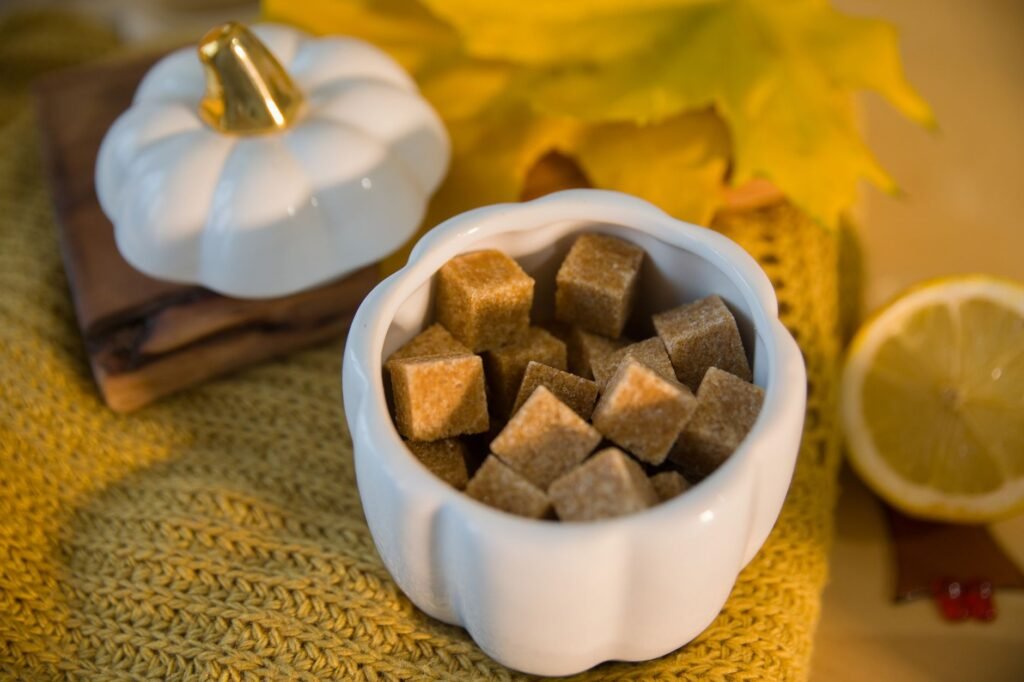 Cozy autumn setup with brown sugar cubes in a pumpkin jar, surrounded by fall decor