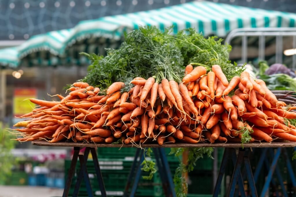 Vibrant bunches of carrots with greens at a local farmers market stand
