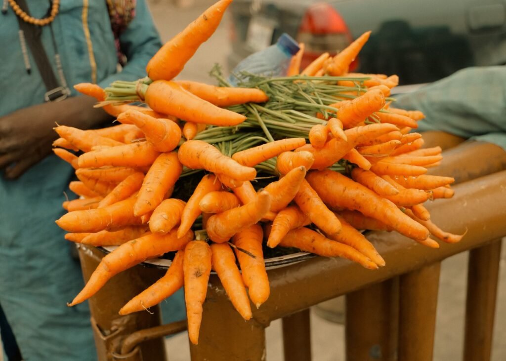 Vibrant bunches of fresh organic carrots displayed at an outdoor market, showcasing natural produce.