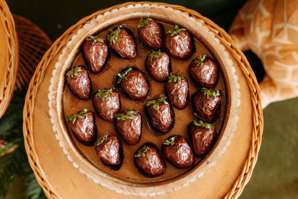 High-angle view of sumptuous chocolate-covered strawberries neatly arranged on a woven tray, enticingly dec...