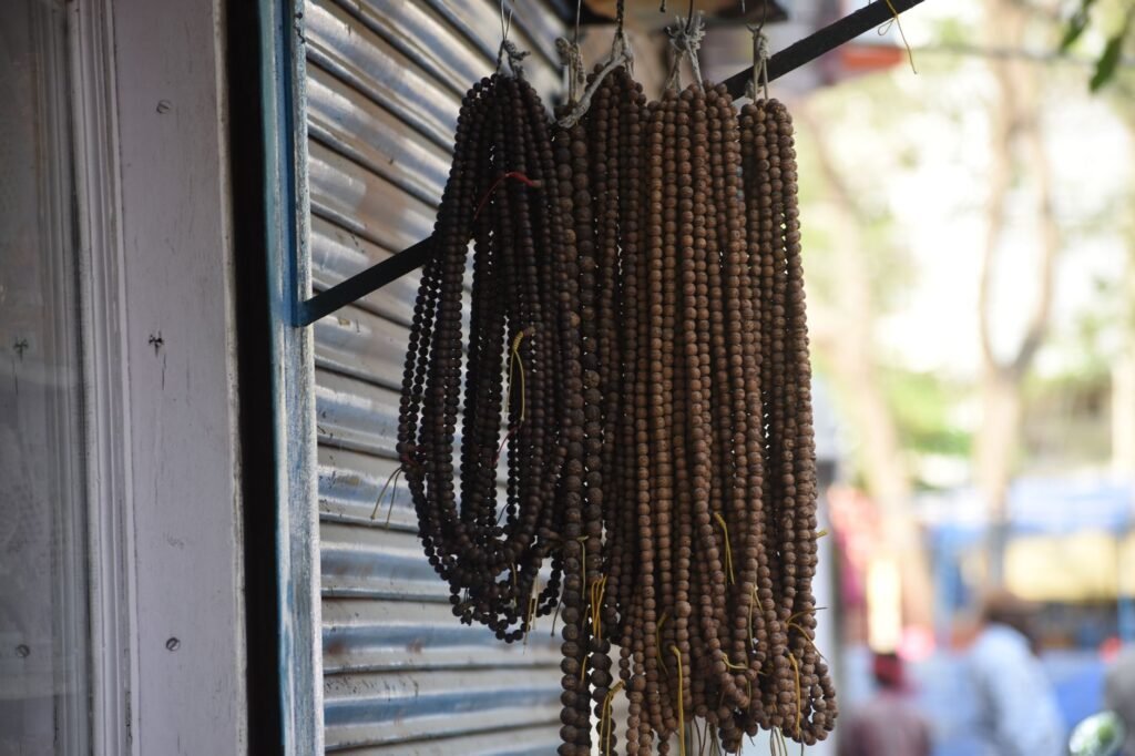 Close-up of handmade bead necklaces hanging on display at a street market.