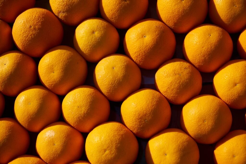 Top-down view of fresh organic oranges arranged closely in a vibrant pattern
