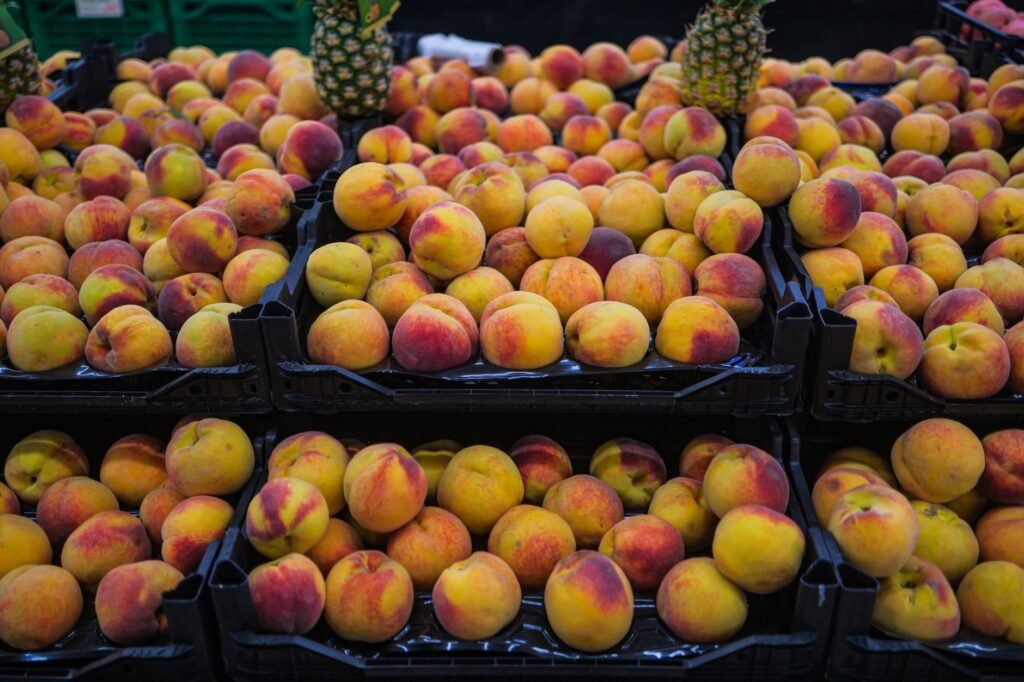 Vibrant display of ripe peaches in a supermarket setting