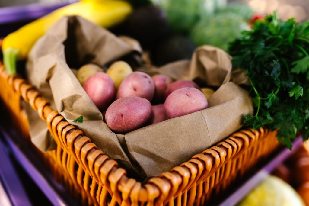Assorted fresh vegetables including potatoes and parsley in a basket