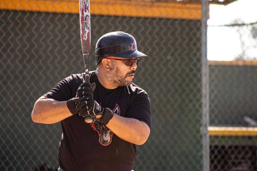 A male baseball player in action, holding a bat, ready to swing during a game