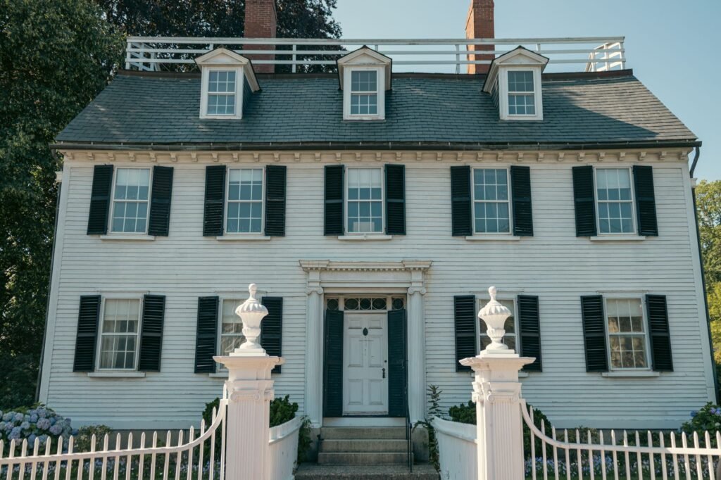 Elegant Colonial-style house with black shutters and white picket fence in Salem, Massachusetts