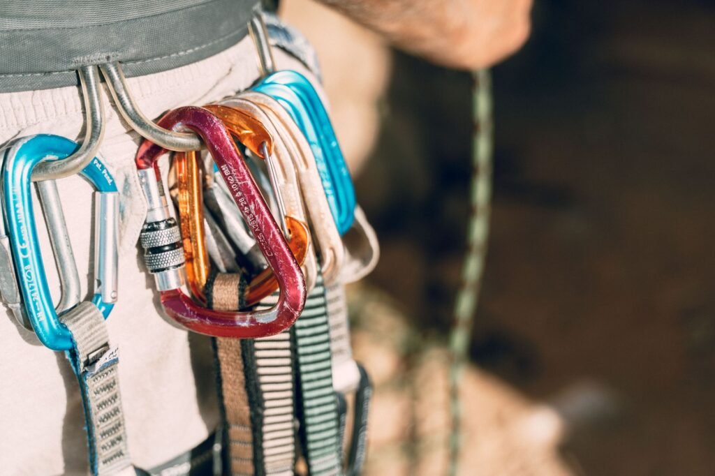 Detailed shot of climbing equipment with various carabiners attached to harness