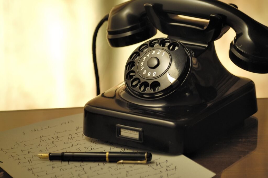 A nostalgic scene with an antique rotary phone and a fountain pen on a desk