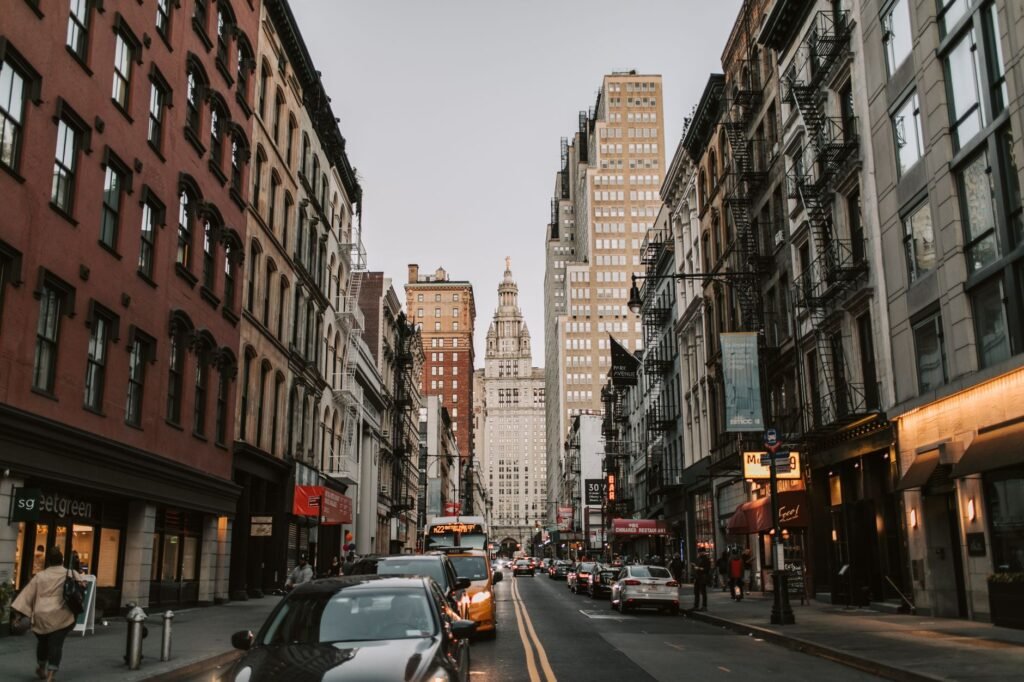 Dynamic street scene with historic facades leading to iconic skyscrapers in New York City