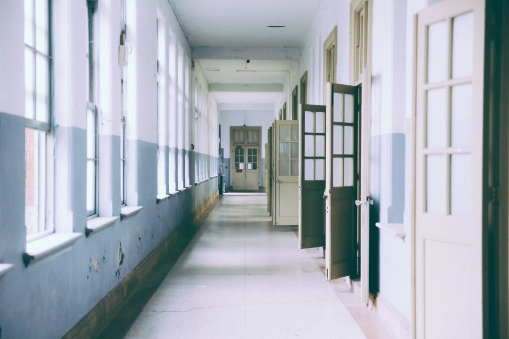 A bright, empty hallway with open doors providing a clear perspective and ample daylight