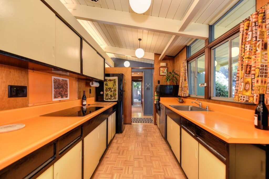Explore this retro mid-century modern kitchen with vibrant countertops and classic design elements