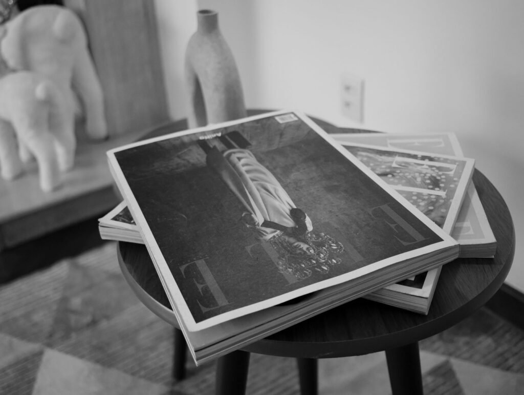 Monochrome image of fashion magazines on a table in a stylish interior setting