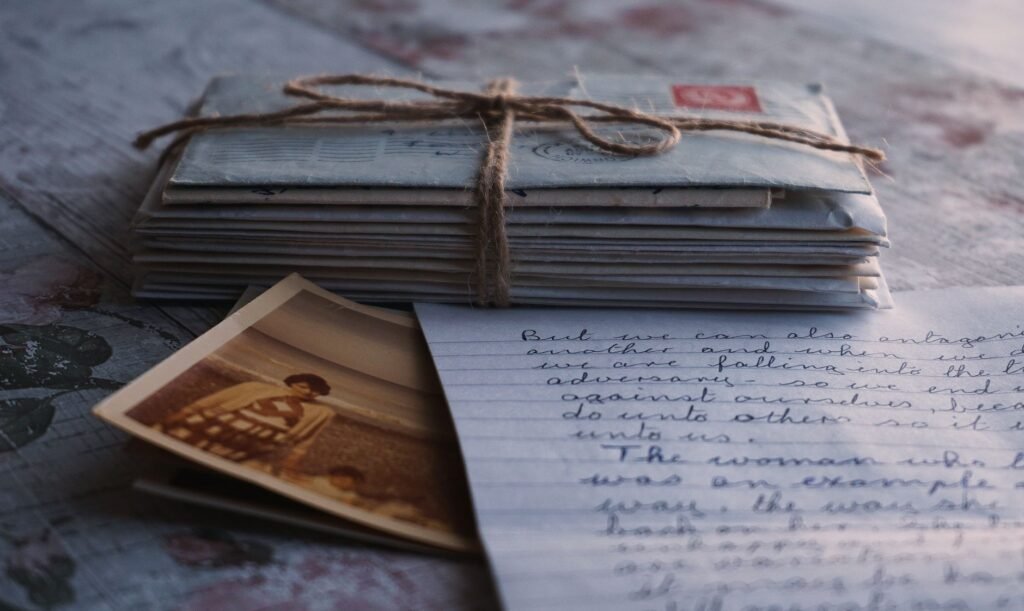 Close-up of vintage letters tied together with a twine, accompanied by an old photograph and handwritten note