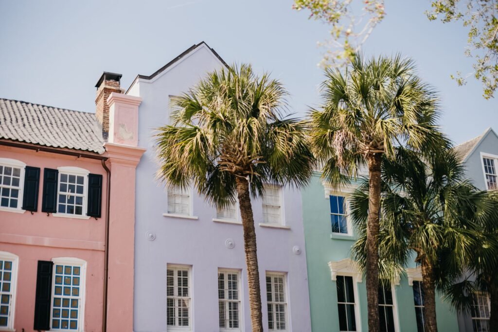 Vibrant pastel homes and palm trees on a sunny street in Charleston