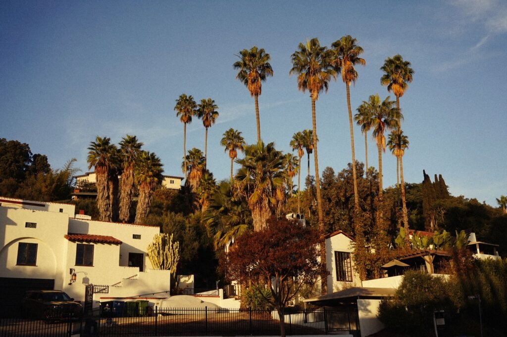 Spanish-style houses with tall palm trees during a warm sunset in Southern California