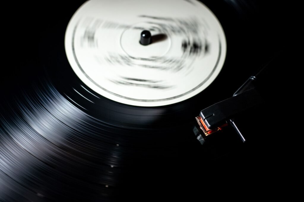 Black vinyl record spinning on a turntable with the stylus resting on the grooves