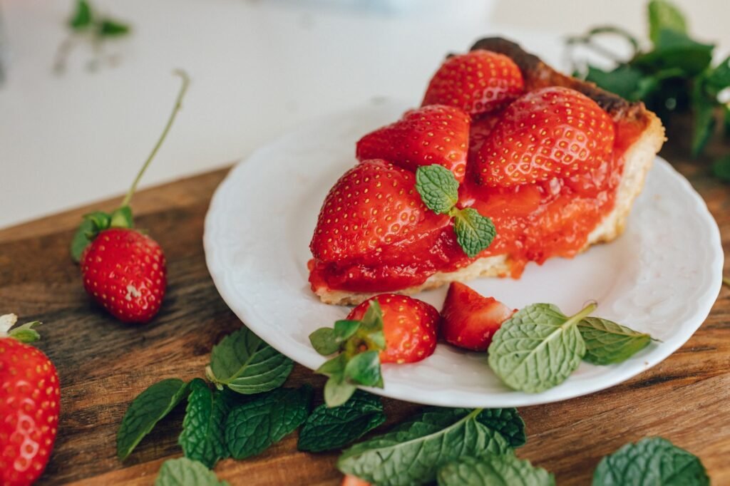 Delicious homemade strawberry tart with fresh mint leaves, showcasing a vibrant and appetizing dessert