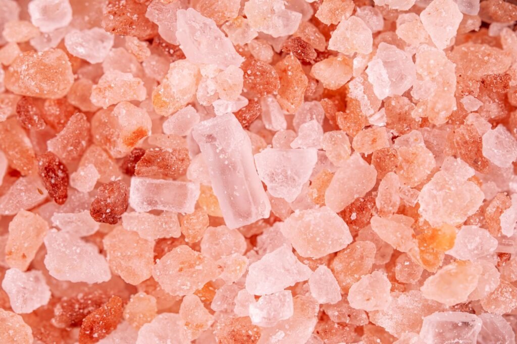 Close view of coarse pink and clear salt crystals piled together