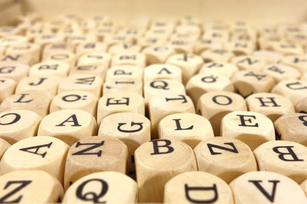 Rows of pale wooden cubes printed with black capital letters packed closely together