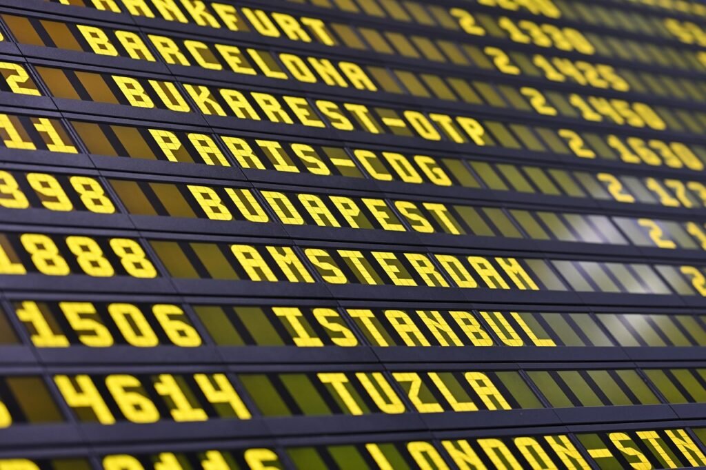 Close view of a split flap departure board with yellow letters listing destinations and times