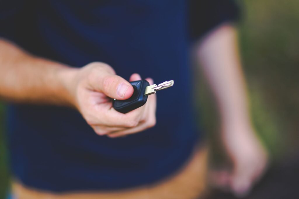 A hand holding a car key outdoors, emphasizing security and control