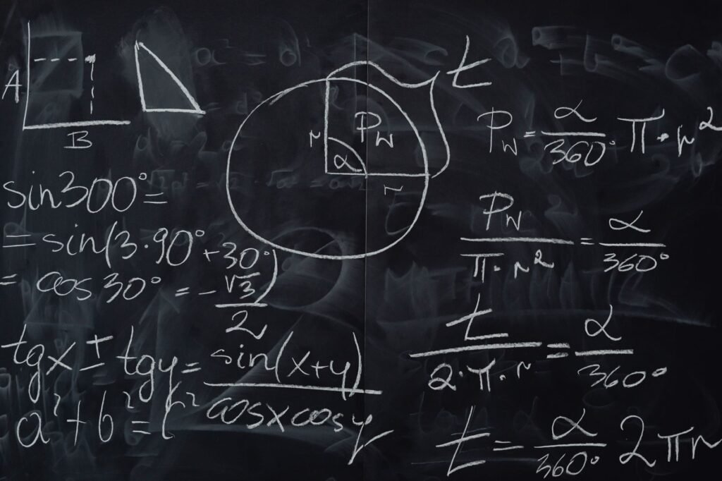 Chalkboard covered in handwritten trigonometry equations, angle formulas, and geometric sketches in white c...