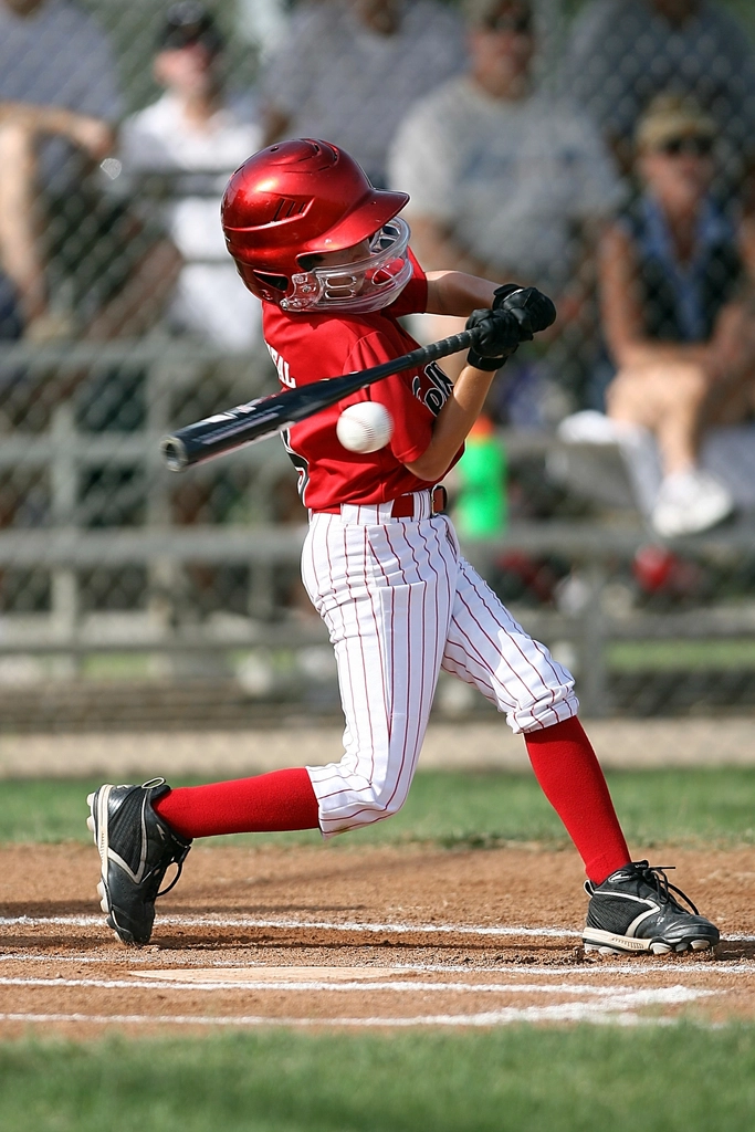 Kid baseball player swinging bat