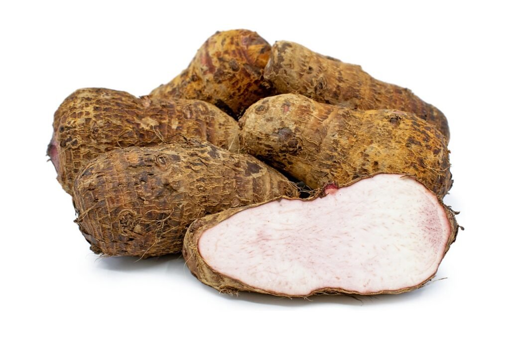 Hairy brown root vegetables, one cut open to show pale flesh flecked with purple
