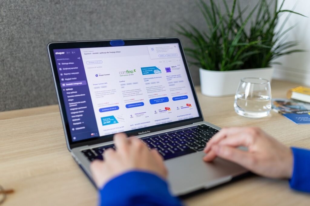 Close-up of hands on a laptop browsing an e-commerce site in a modern office