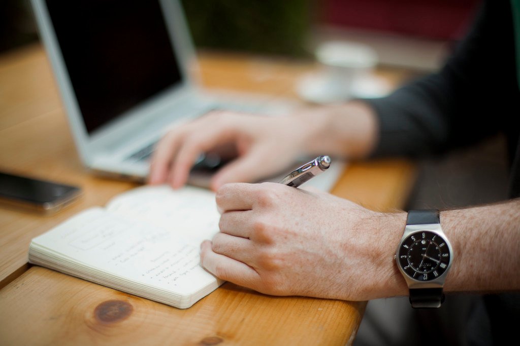 Writing in Notebook at Desk