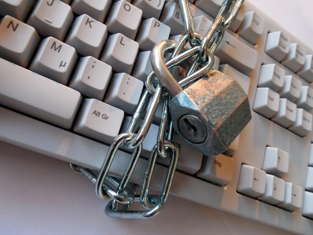 Metal chain and padlock wrapped around a light gray computer keyboard