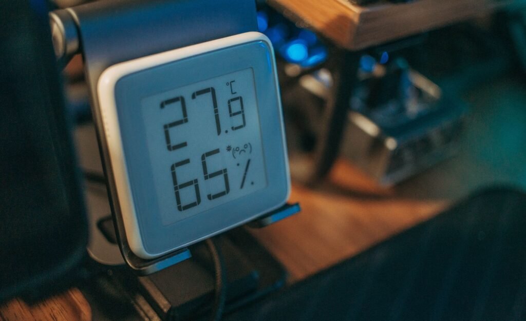 A digital room thermometer showing temperature and humidity